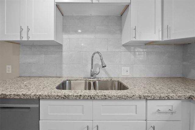 kitchen featuring tasteful backsplash, white cabinetry, and sink