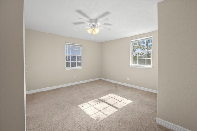 carpeted spare room featuring ceiling fan