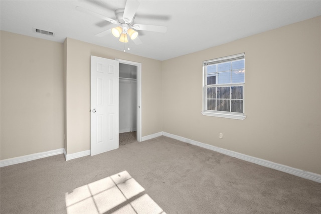 unfurnished bedroom featuring ceiling fan, light colored carpet, and a closet