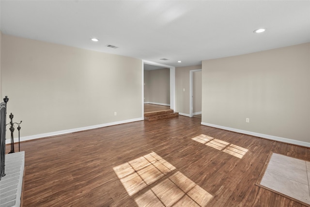 unfurnished room with dark hardwood / wood-style flooring and a brick fireplace