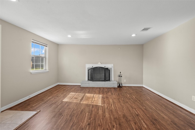 unfurnished living room featuring a fireplace and hardwood / wood-style floors