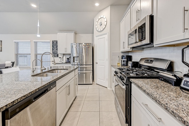 kitchen featuring sink, white cabinetry, stainless steel appliances, light tile patterned floors, and light stone counters