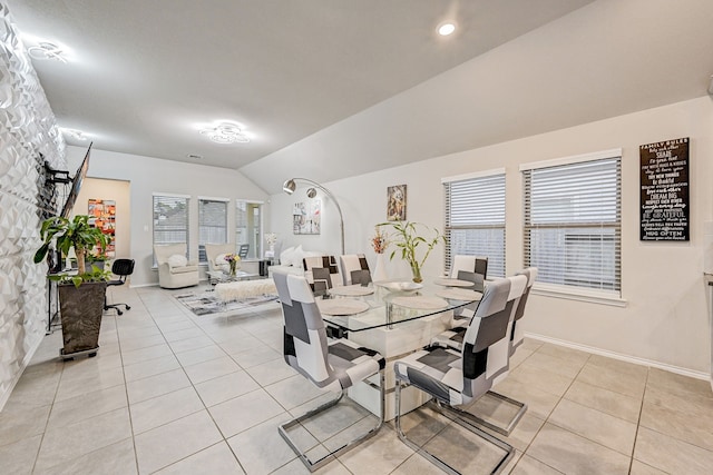 tiled dining space featuring a healthy amount of sunlight and lofted ceiling