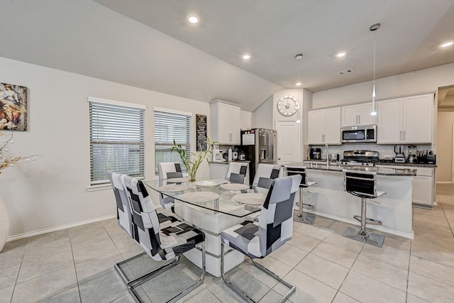 dining space featuring lofted ceiling and light tile patterned floors