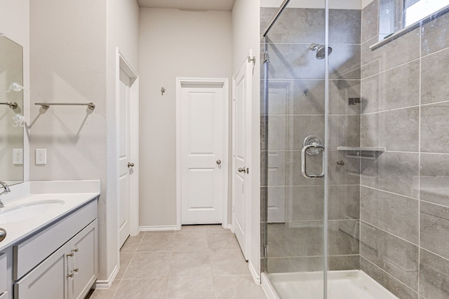 bathroom featuring a shower with shower door, tile patterned floors, and vanity