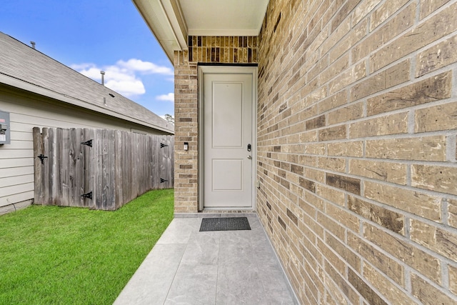 view of exterior entry with a lawn