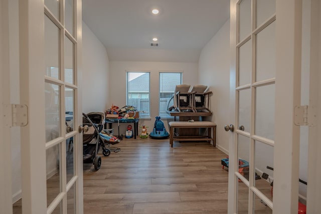 interior space with vaulted ceiling, light wood-type flooring, and french doors