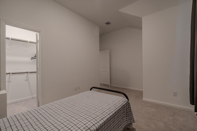 carpeted bedroom featuring lofted ceiling and a closet