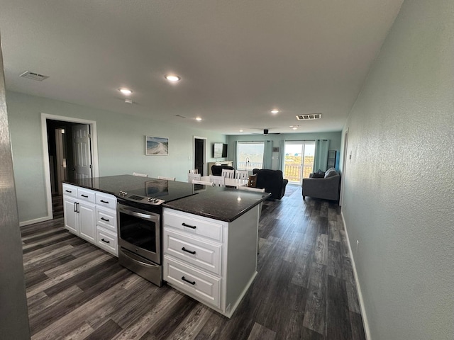 kitchen featuring electric stove, dark wood finished floors, visible vents, white cabinets, and baseboards