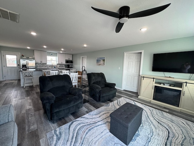 living room featuring ceiling fan and hardwood / wood-style floors