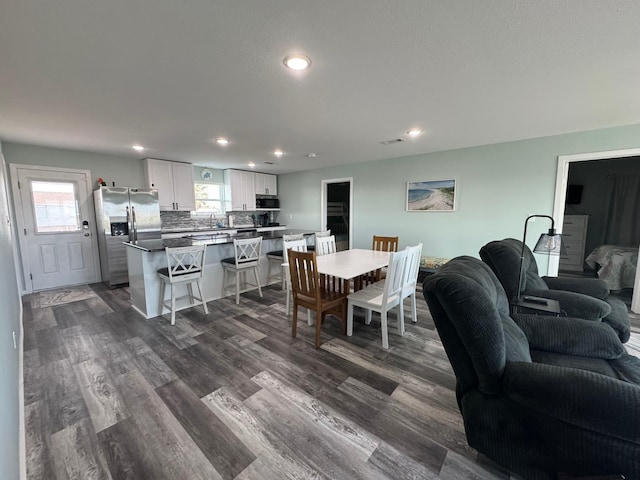 dining area with a healthy amount of sunlight, dark hardwood / wood-style floors, and sink