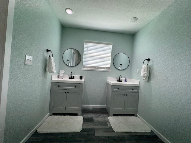 bathroom featuring a textured ceiling, hardwood / wood-style floors, and vanity