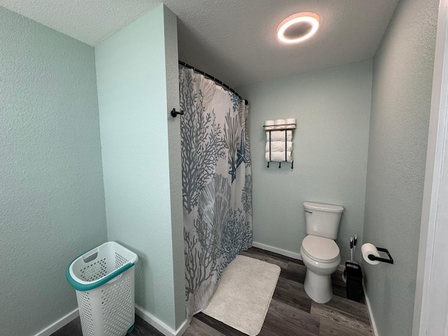 bathroom featuring hardwood / wood-style floors, toilet, a textured ceiling, and a shower with curtain