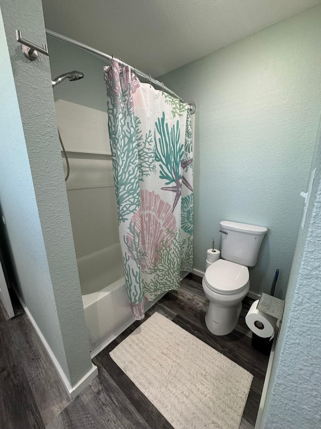 bathroom featuring toilet, shower / bath combination with curtain, and wood-type flooring