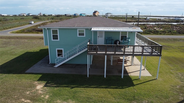 rear view of property featuring a lawn, a patio area, and a wooden deck