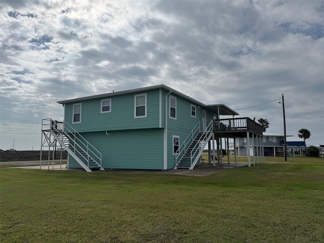 back of property with stairs, a deck, a lawn, and a patio