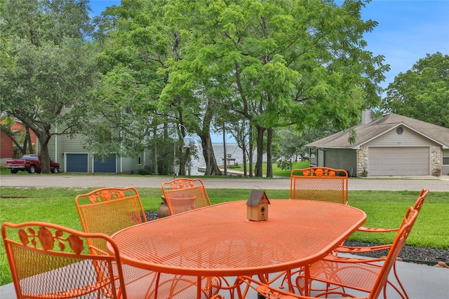 view of patio featuring a water view and a garage