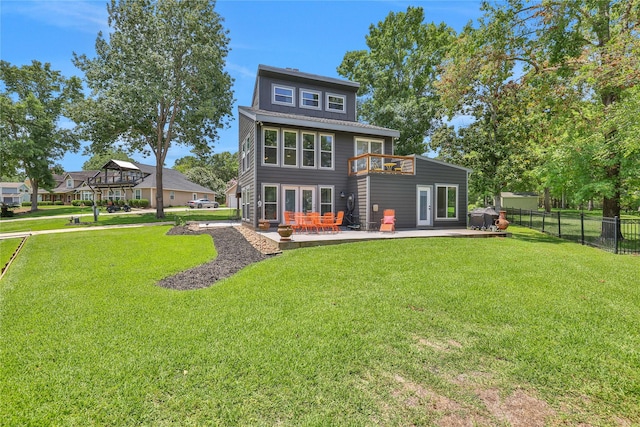 back of property with a lawn, a balcony, and a patio