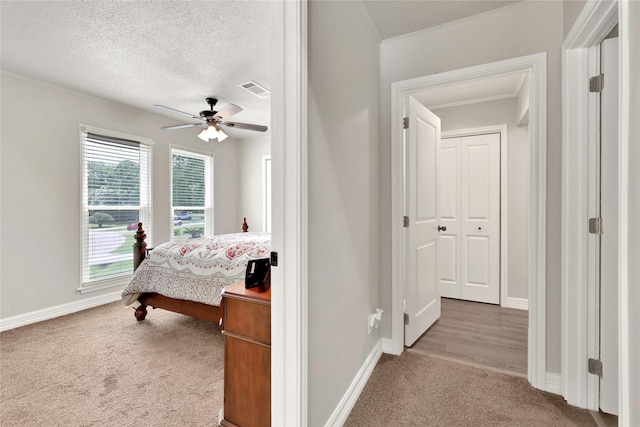 carpeted bedroom featuring ceiling fan, a textured ceiling, and a closet