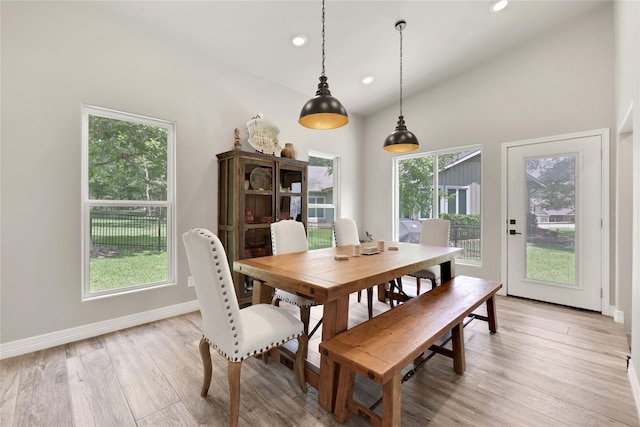 dining room featuring high vaulted ceiling and light wood-type flooring