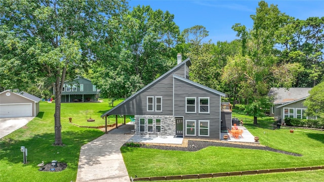 back of property with a yard, a patio, an outdoor structure, and a garage