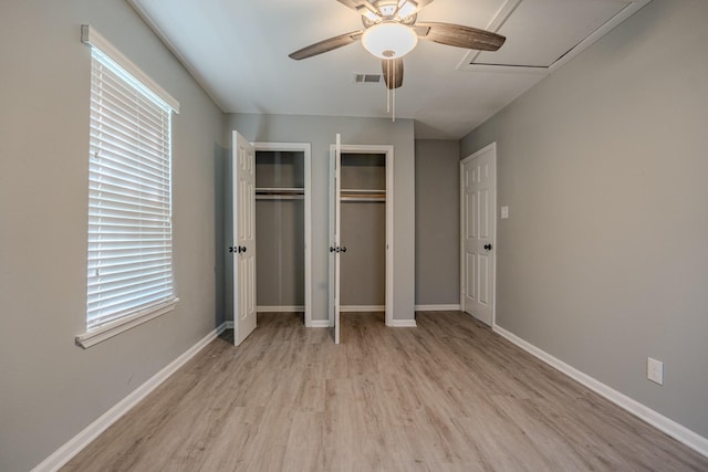 unfurnished bedroom featuring ceiling fan, light hardwood / wood-style floors, and multiple windows