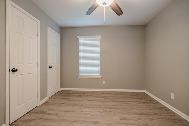 unfurnished room with ceiling fan and light wood-type flooring