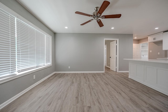 unfurnished living room with light wood-type flooring and ceiling fan