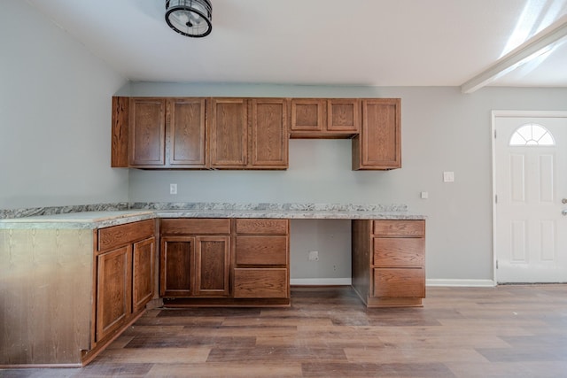 kitchen with hardwood / wood-style floors, beam ceiling, and built in desk