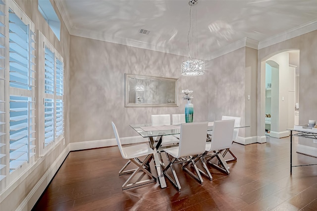 dining room featuring a wealth of natural light, dark hardwood / wood-style flooring, crown molding, and a notable chandelier