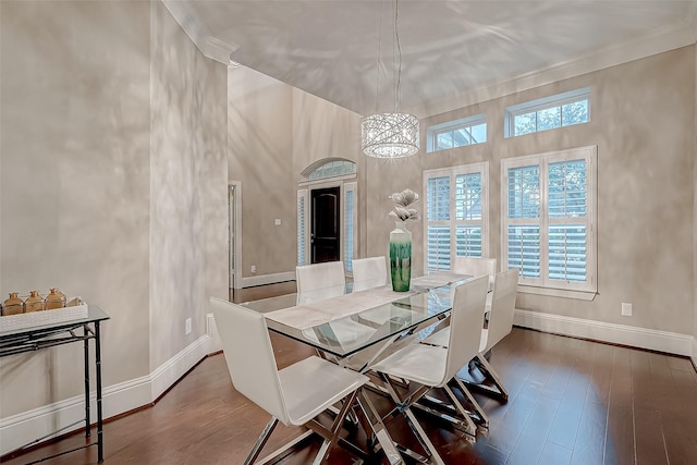 dining space with a chandelier, wood-type flooring, and ornamental molding