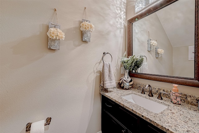 bathroom with vanity and vaulted ceiling