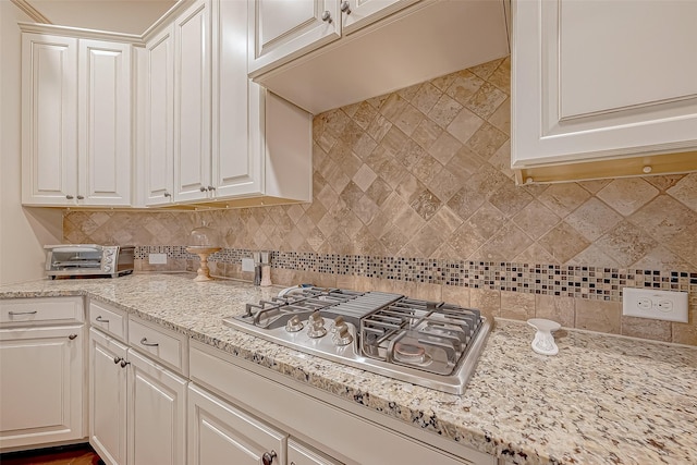 kitchen with white cabinetry, light stone countertops, and stainless steel gas cooktop