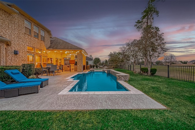 pool at dusk with a lawn and a patio