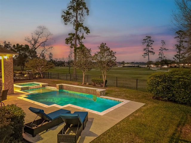 pool at dusk with an in ground hot tub, a yard, and a patio