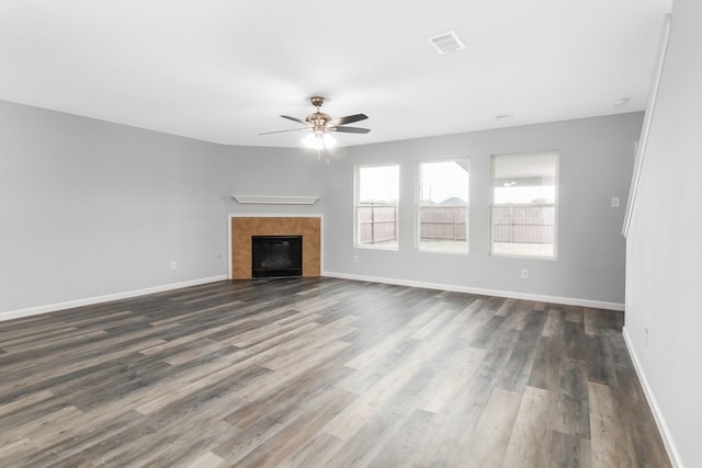 unfurnished living room with ceiling fan, a fireplace, and dark hardwood / wood-style floors