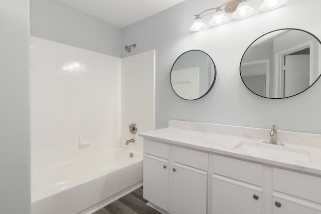 bathroom with  shower combination, hardwood / wood-style floors, and vanity