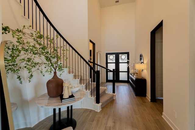 entrance foyer featuring a high ceiling, french doors, and wood-type flooring