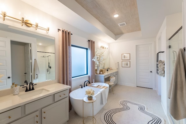 bathroom with a raised ceiling, plus walk in shower, tile patterned floors, and vanity