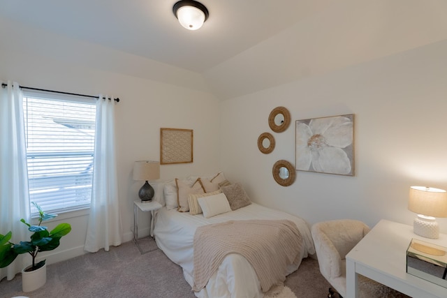 carpeted bedroom with lofted ceiling and multiple windows