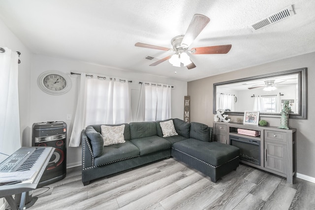 living room with light hardwood / wood-style floors and a textured ceiling