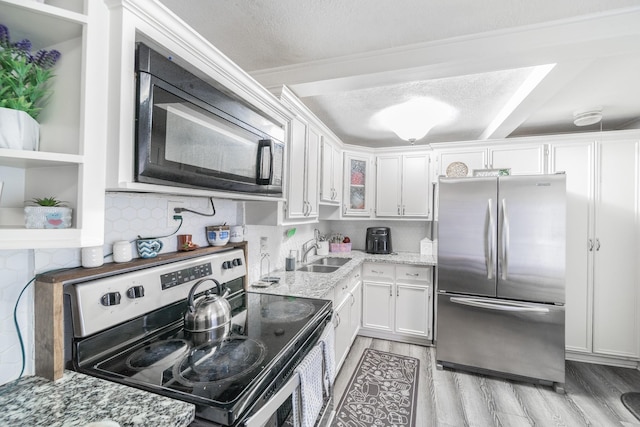 kitchen with a textured ceiling, white cabinetry, sink, and appliances with stainless steel finishes