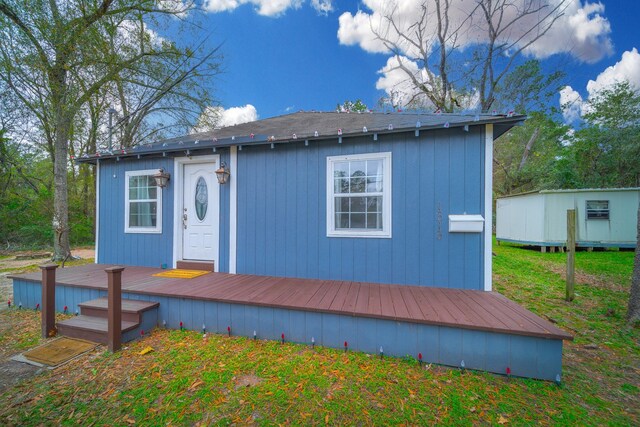 exterior space featuring a front yard, a shed, and a wooden deck