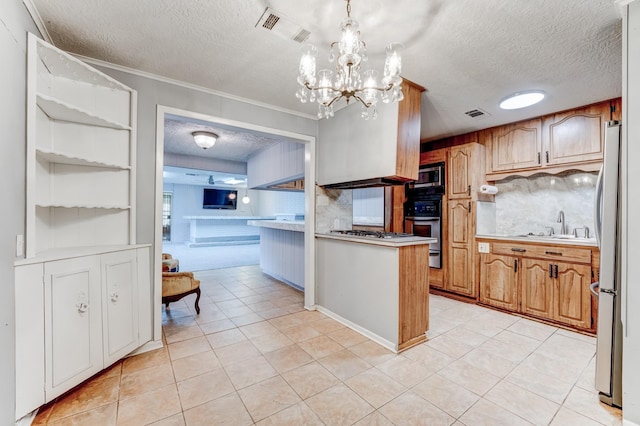 kitchen featuring kitchen peninsula, a textured ceiling, stainless steel appliances, an inviting chandelier, and hanging light fixtures