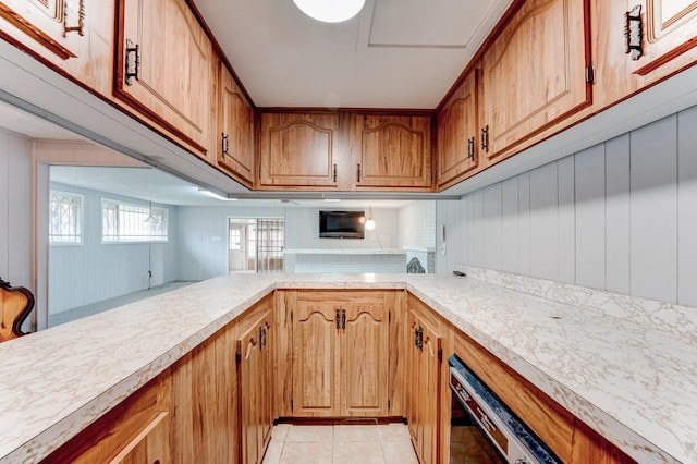 kitchen with light tile patterned floors and wooden walls