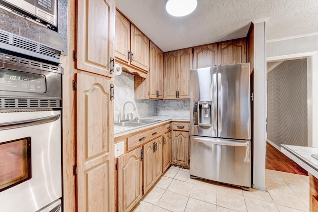 kitchen with stainless steel refrigerator with ice dispenser, a textured ceiling, crown molding, sink, and light tile patterned floors