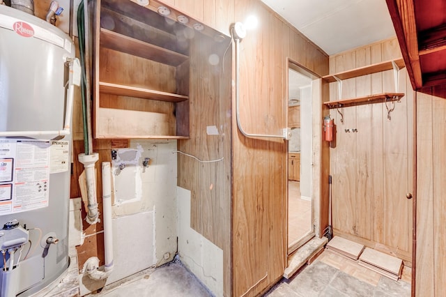 interior space with wooden walls and gas water heater