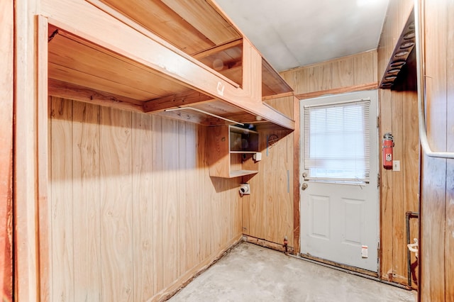 doorway to outside featuring wooden walls