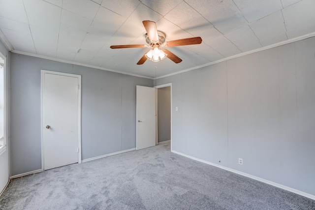 carpeted empty room featuring ceiling fan and ornamental molding