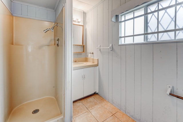 bathroom with tile patterned flooring, vanity, a shower, and wooden walls